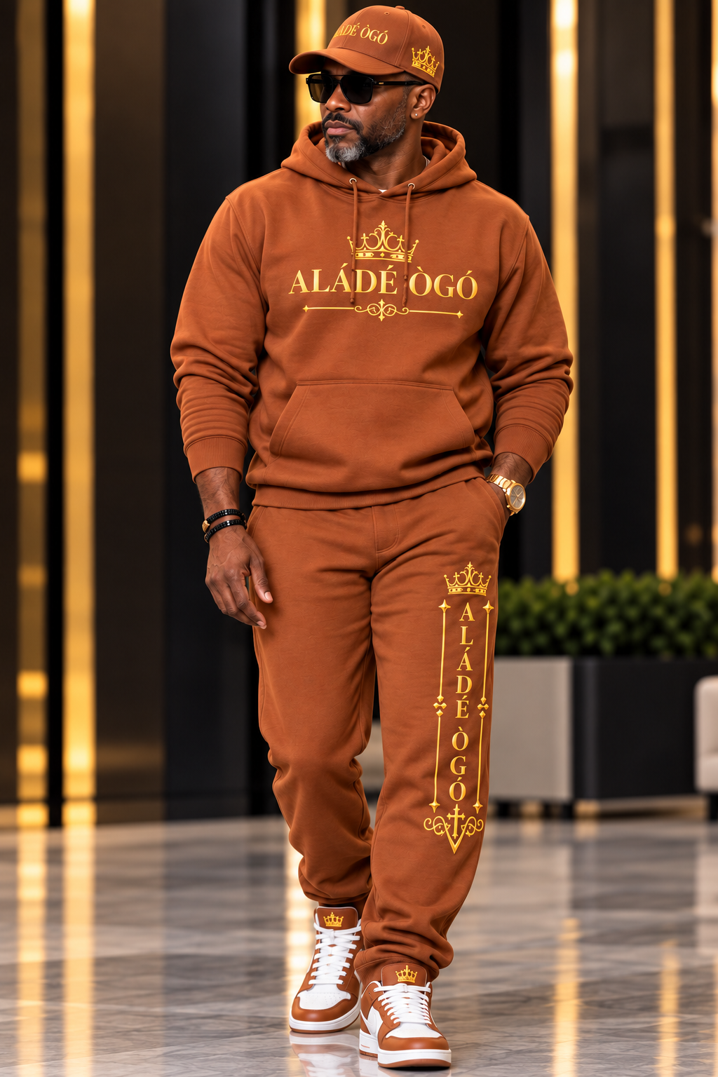 Man wearing the caramel ALÁDÉ ÒGÓ hoodie, matching sweatpants and snapback