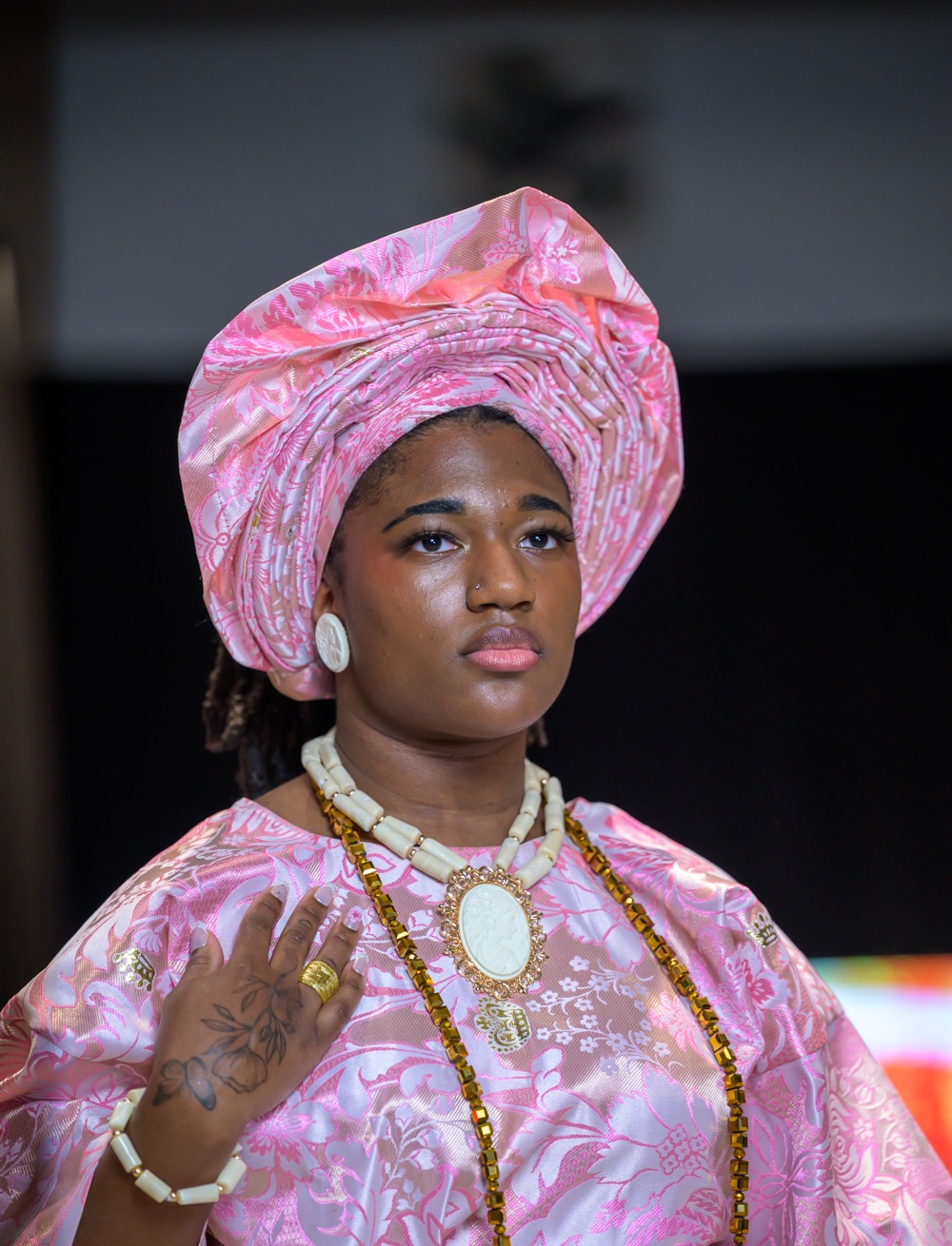 Adeyemi RoyaLabel model in ornate pink heritage garment and headwrap at Heartland International Fashion Week Season Six